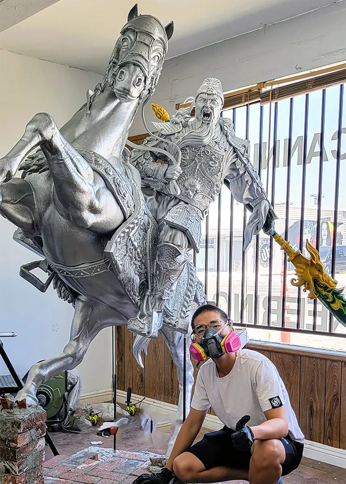 The Prozix team assembling and finishing a life-size 3D printed statue of the legendary Chinese general Guan Yu, featuring intricate armor and weapon details.