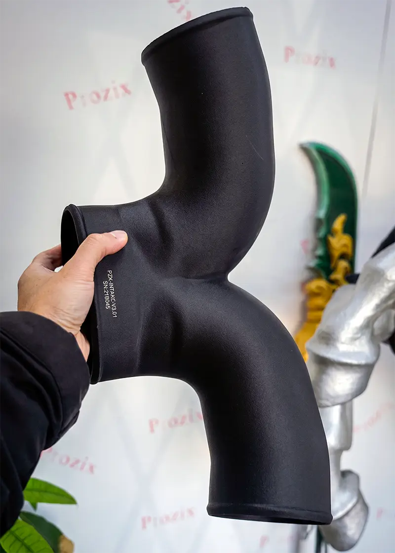 A functional 3D printed intake manifold made from PPS-CF composite, capable of withstanding 200°C temperatures and constant exposure to oil and fuel.